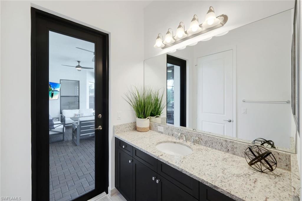4549 Azalea Drive Naples, FL 34119 - Photo 31 of 49 a bathroom with a granite countertop sink and a mirror