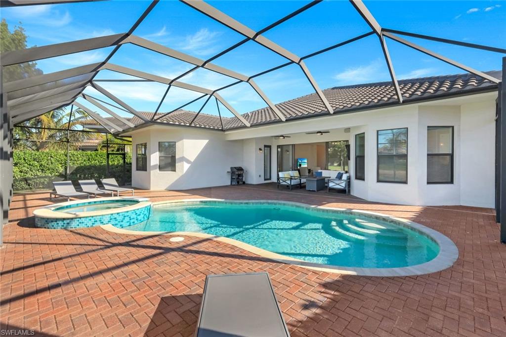 4549 Azalea Drive Naples, FL 34119 - Photo 37 of 49 a view of a backyard with table and chairs under an umbrella