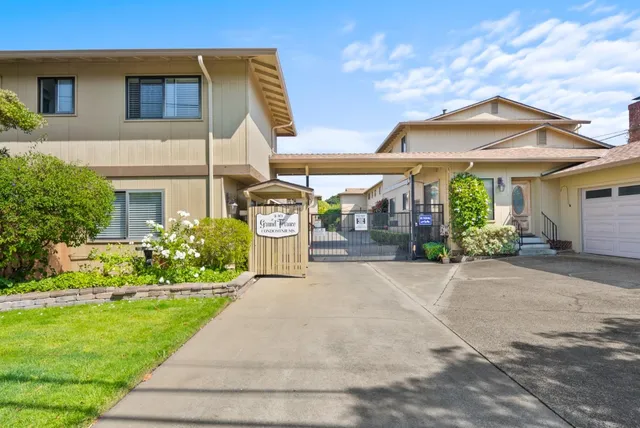 a front view of a house with a garden and plants