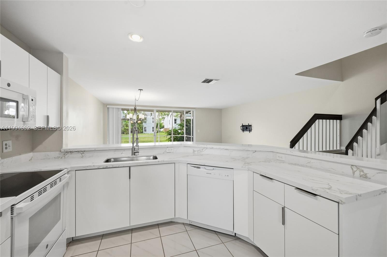6215 Old Court Road, Unit 505 Boca Raton, FL 33433 - Photo 9 of 36 a kitchen with white cabinets appliances and sink