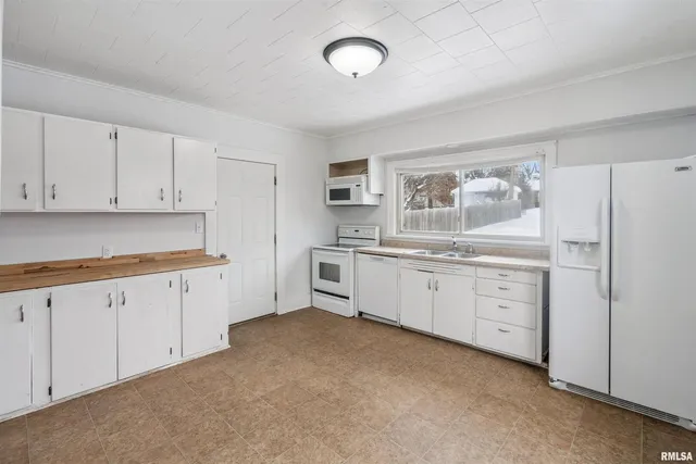 a kitchen with white cabinets and white appliances
