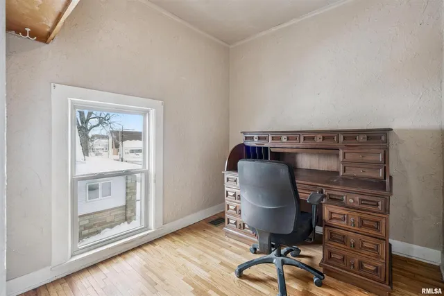 a view of a workspace with furniture and a window