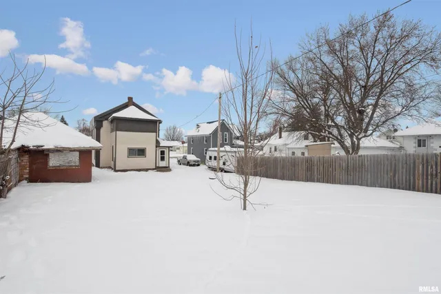 a view of house with a yard and covered with snow