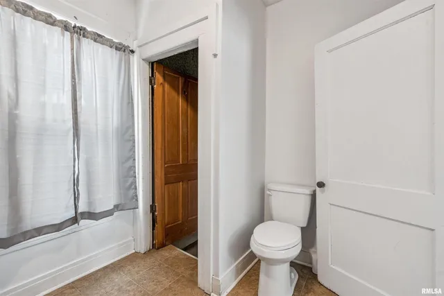 a white toilet sitting next to a shower
