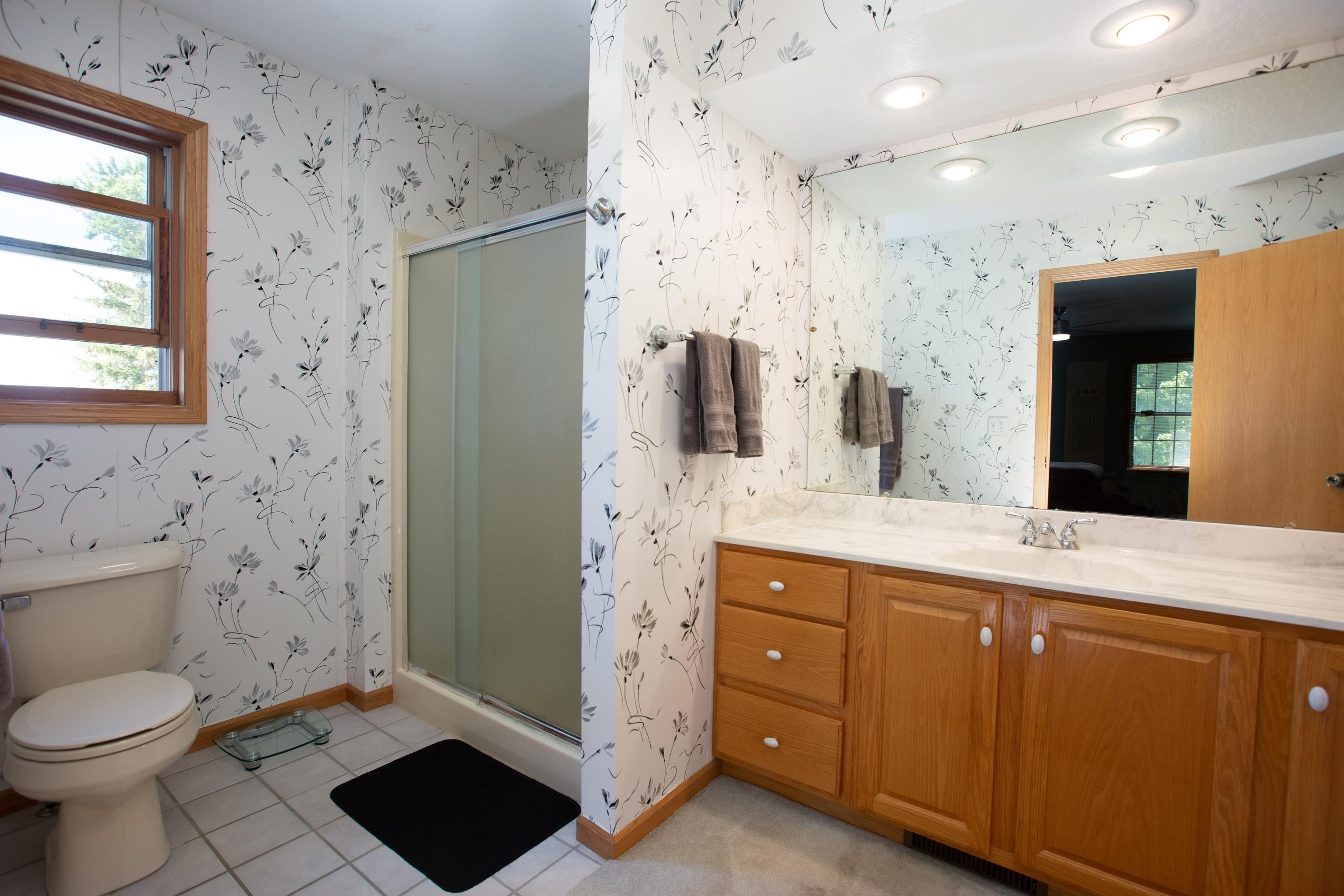 17092 Blackhawk Road Shullsburg, WI 53586 - Photo 23 of 50 a spacious bathroom with a granite countertop sink a toilet and a shower