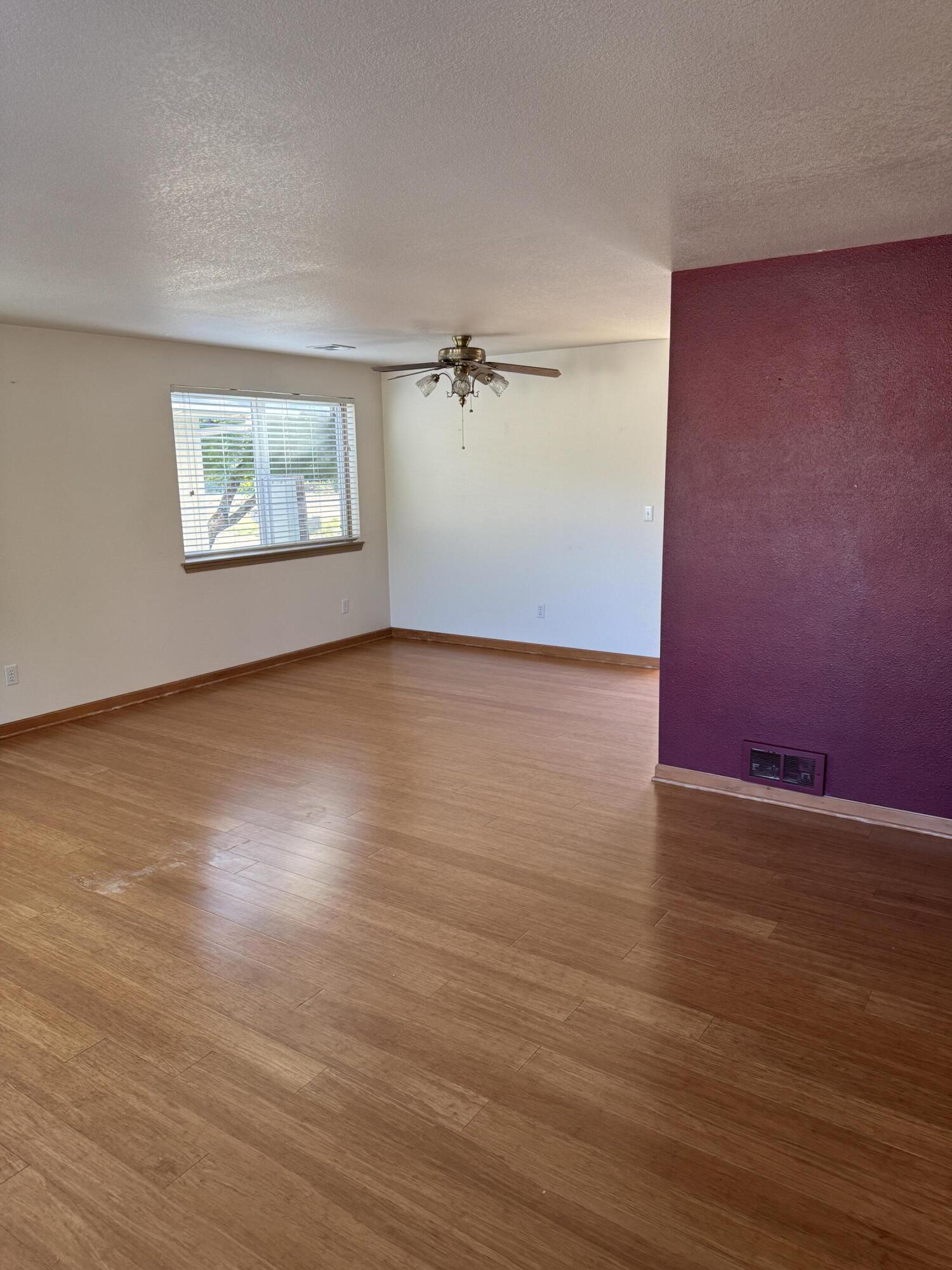 7165 Old Stage Road Central Point, OR 97502 - Photo 17 of 18 an empty room with wooden floor ceiling fan and windows