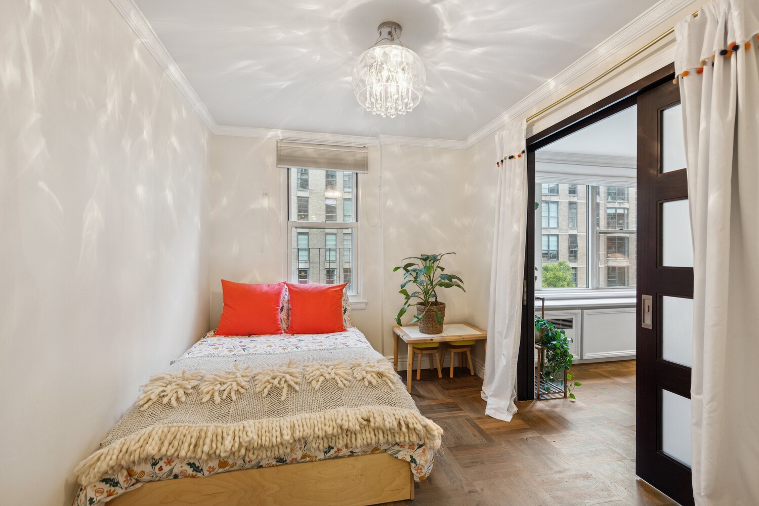 13 West 13th Street, Unit 7FS Manhattan, NY 10011 - Photo 8 of 11 a bedroom with a bed and a chandelier