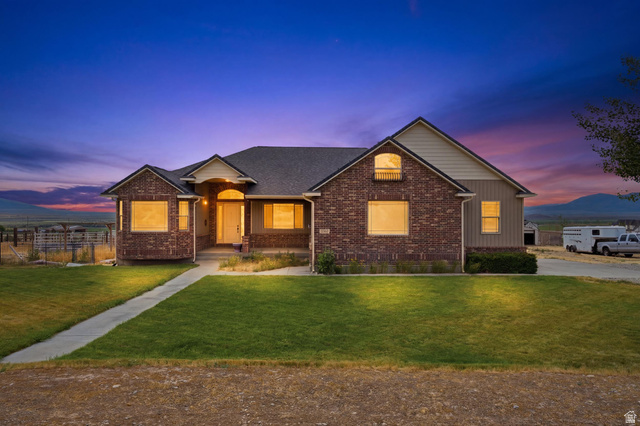 2567 West Rim Rock Drive Stockton, UT 84071 - Photo 1 of 64 Brick and siding exterior featuring a covered entry porch with an arched doorway