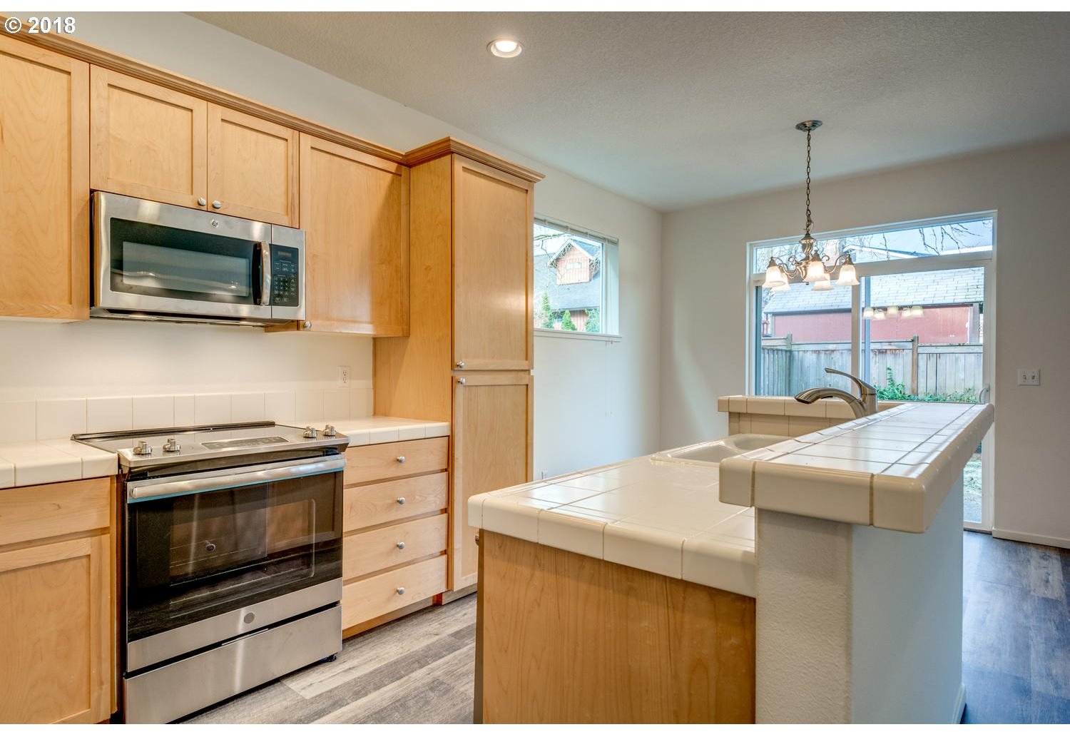 20591 Southwest Ravenswood Street Beaverton, OR 97078 - Photo 11 of 31 a kitchen with stainless steel appliances granite countertop a stove a microwave oven with white cabinets