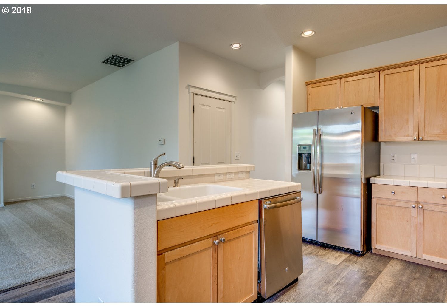 20591 Southwest Ravenswood Street Beaverton, OR 97078 - Photo 12 of 31 a kitchen with a sink a stove a refrigerator and cabinets