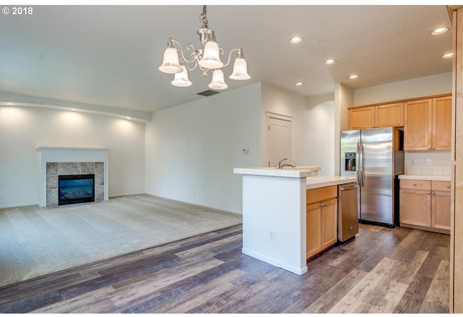 20591 Southwest Ravenswood Street Beaverton, OR 97078 - Photo 13 of 31 a kitchen with stainless steel appliances granite countertop a stove a sink dishwasher and a refrigerator with wooden floor
