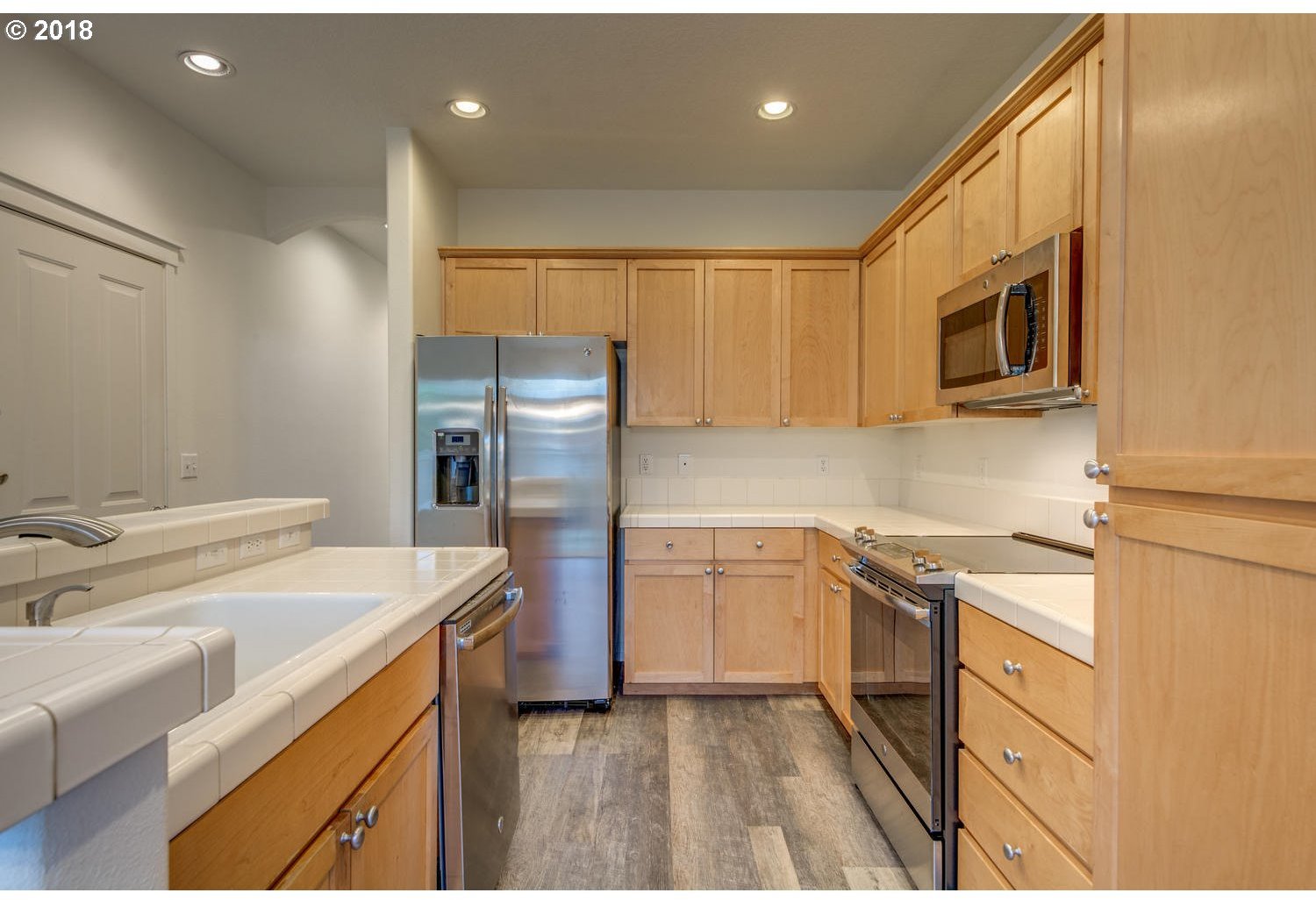 20591 Southwest Ravenswood Street Beaverton, OR 97078 - Photo 14 of 31 a kitchen with a sink stainless steel appliances and cabinets