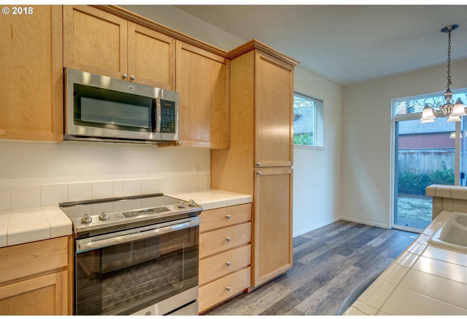 20591 Southwest Ravenswood Street Beaverton, OR 97078 - Photo 16 of 31 a kitchen with stainless steel appliances a stove microwave and refrigerator