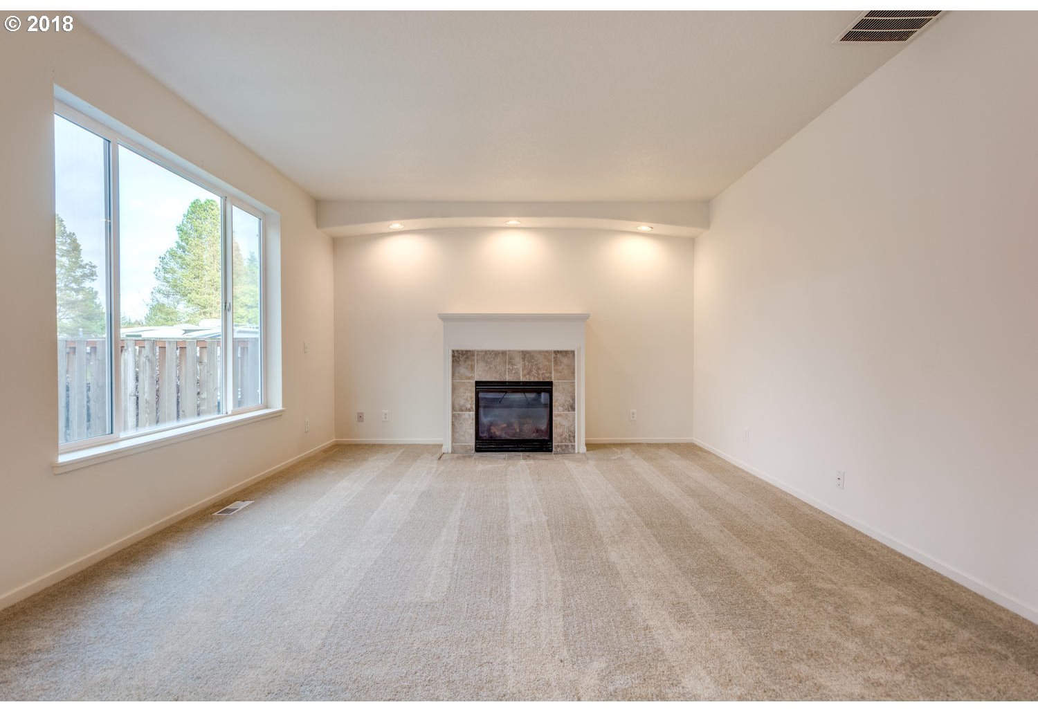 20591 Southwest Ravenswood Street Beaverton, OR 97078 - Photo 19 of 31 a view of an empty room with a window and fireplace