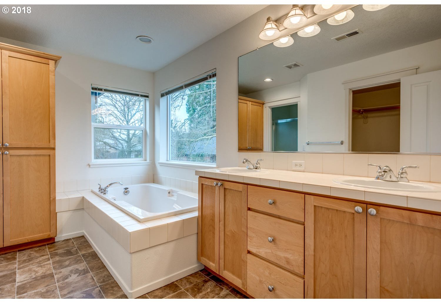 20591 Southwest Ravenswood Street Beaverton, OR 97078 - Photo 24 of 31 a spacious bathroom with a tub double sink window and mirror