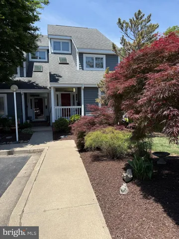 a front view of a house with a garden and plants