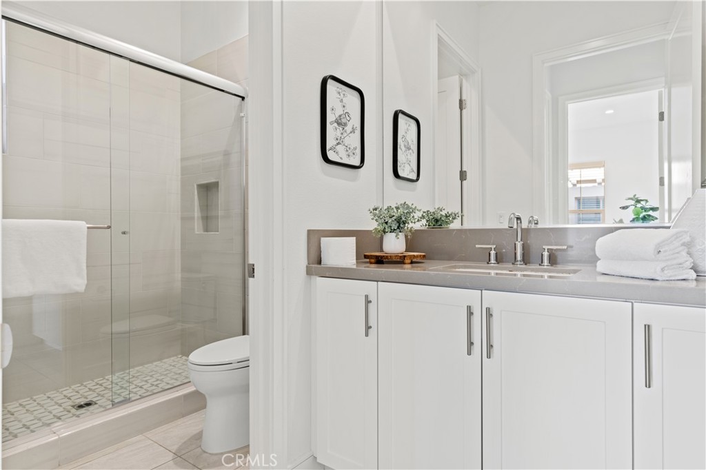 113 Halworth Irvine, CA 92618 - Photo 16 of 30 a bathroom with a granite countertop sink a toilet and a shower