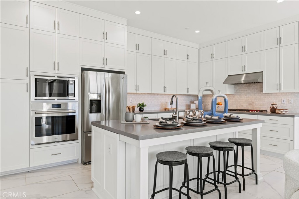 113 Halworth Irvine, CA 92618 - Photo 9 of 30 a kitchen with stainless steel appliances a stove a sink refrigerator and white cabinets