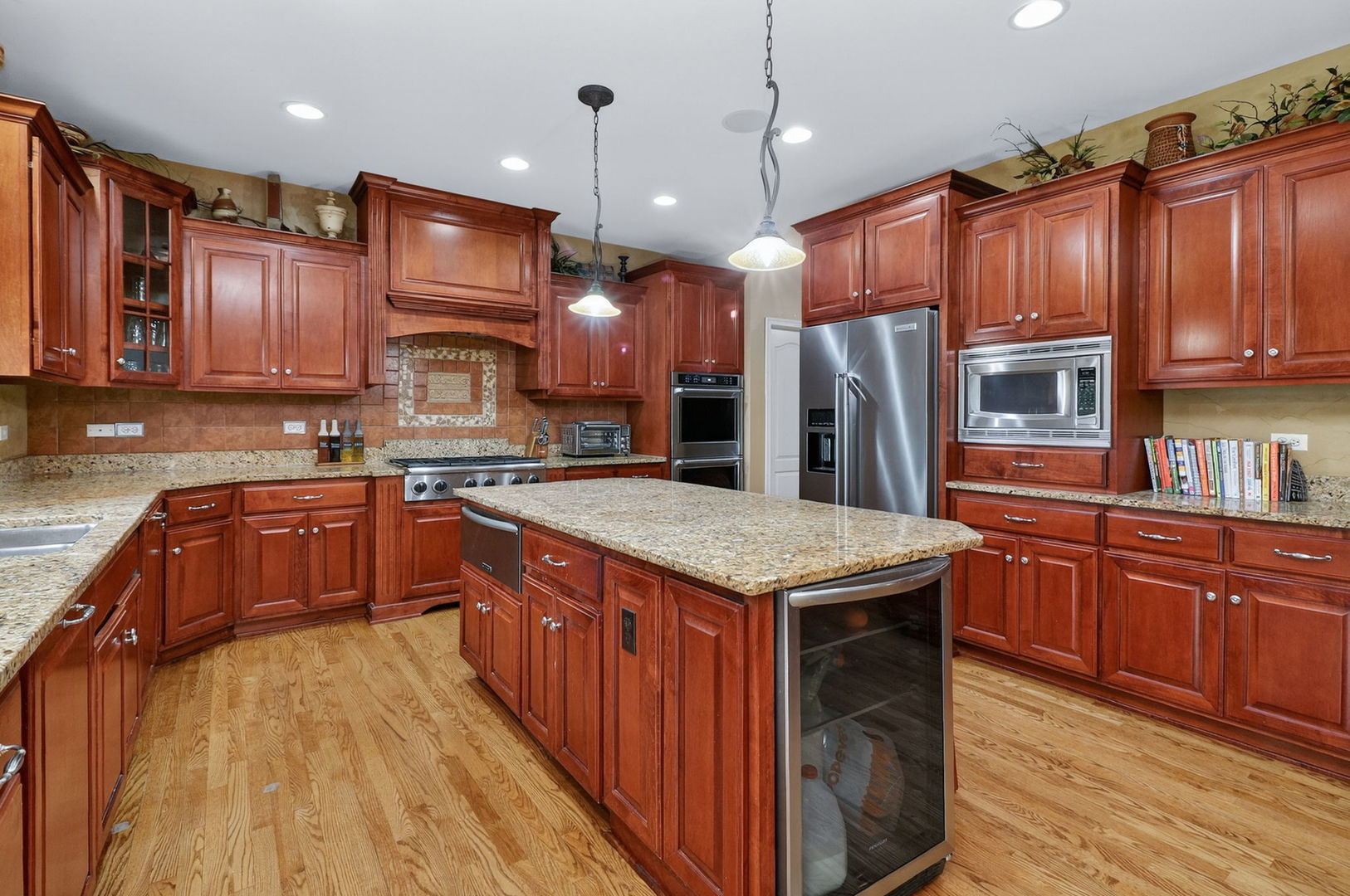 1 Crenshaw Court Bolingbrook, IL 60490 - Photo 9 of 56 a kitchen with kitchen island granite countertop wooden cabinets stainless steel appliances a sink and a center island