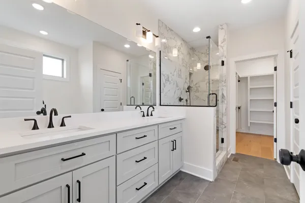a bathroom with a double vanity sink mirror double and shower