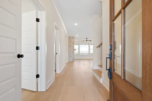 a view of a hallway with wooden floor and staircase