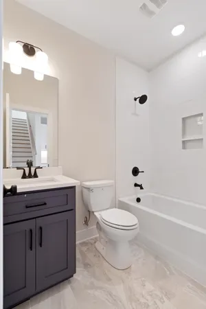 a bathroom with a granite countertop toilet a sink and a mirror