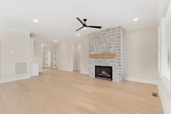 an empty room with fireplace and fan