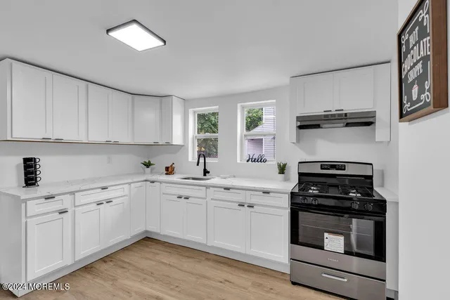 a kitchen with white cabinets and appliances