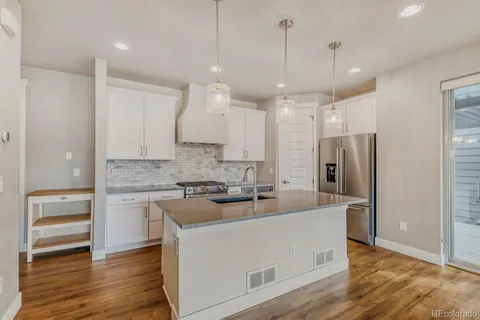 a large kitchen with cabinets wooden floor and a stainless steel appliances