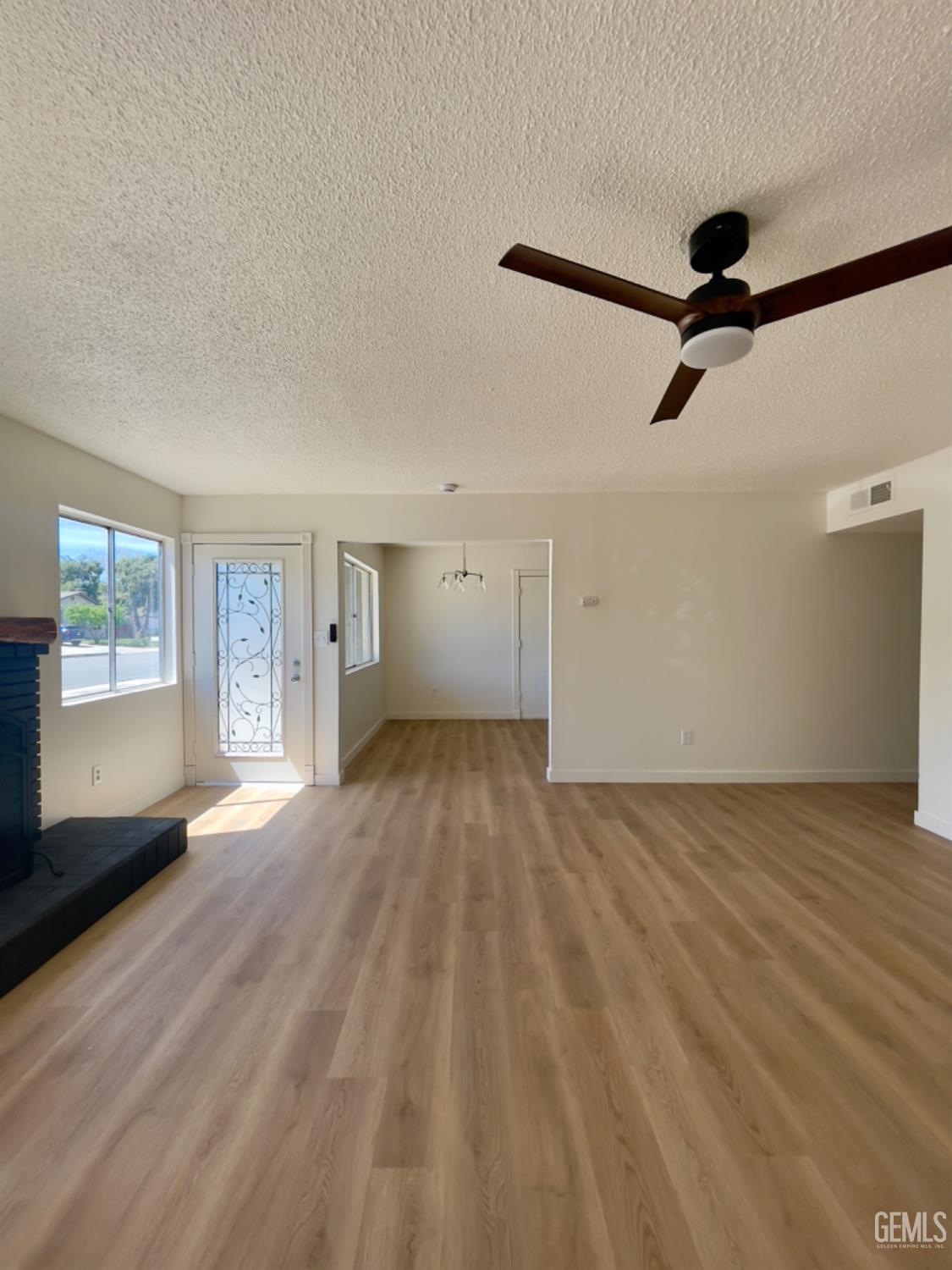 Undisclosed Address Tehachapi, CA 93561 - Photo 3 of 18 a view of empty room with wooden floor and fan