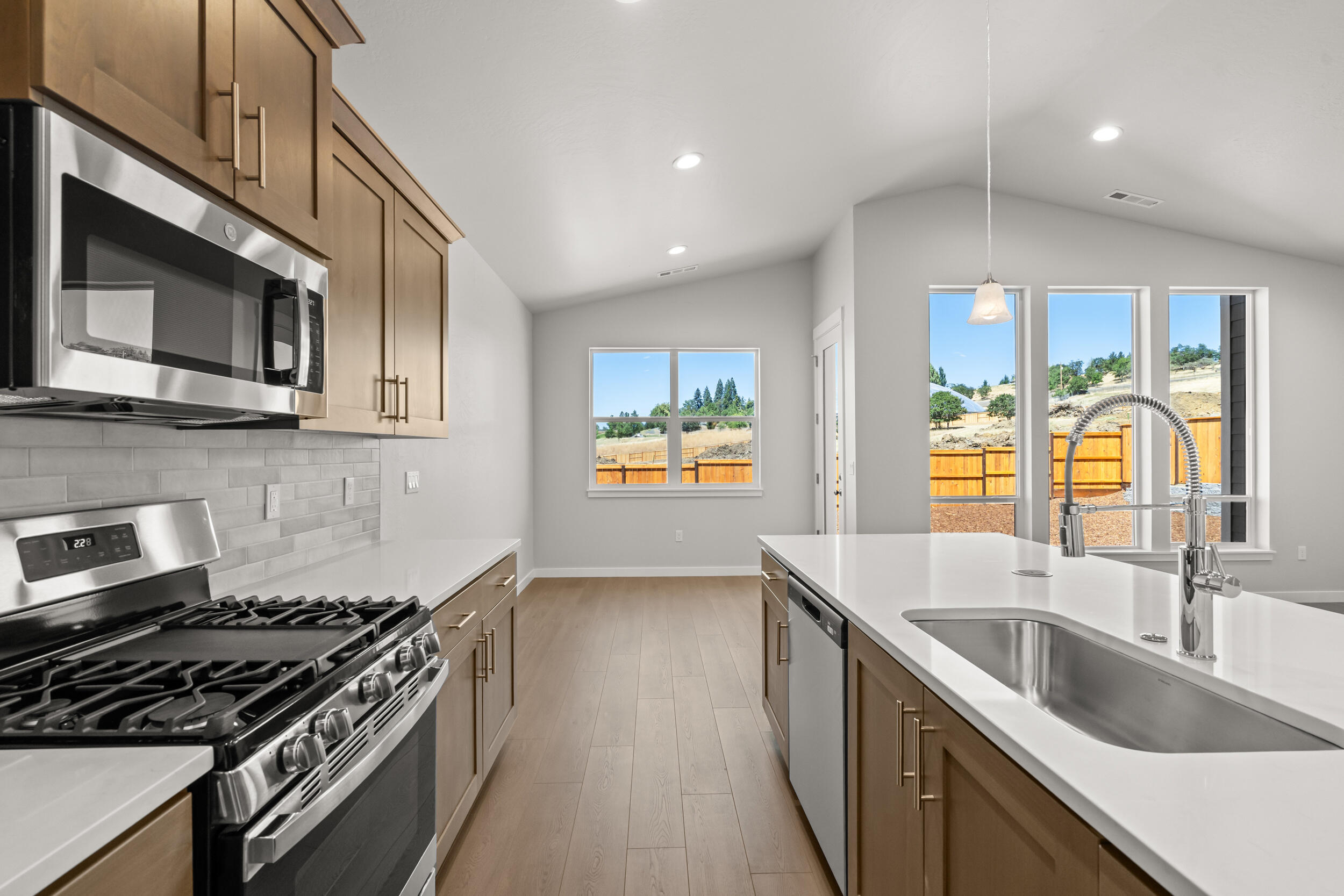 1141 Pumpkin Ridge, Unit 320 Eagle Point, OR 97524 - Photo 8 of 25 a kitchen with stainless steel appliances granite countertop a sink a stove and a wooden floors