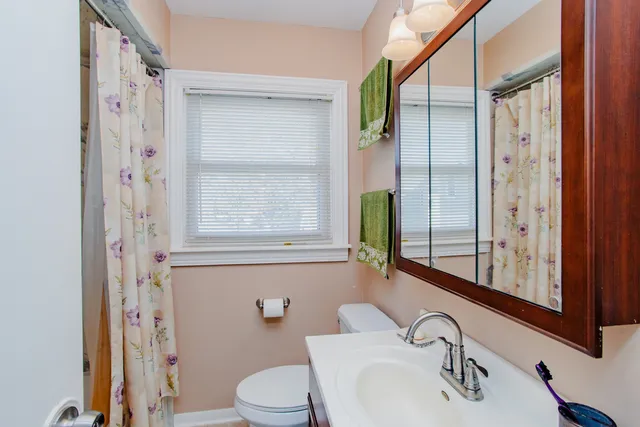 a bathroom with a sink a toilet and a mirror