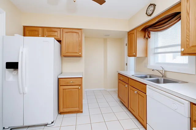 a kitchen with stainless steel appliances granite countertop a sink and a refrigerator