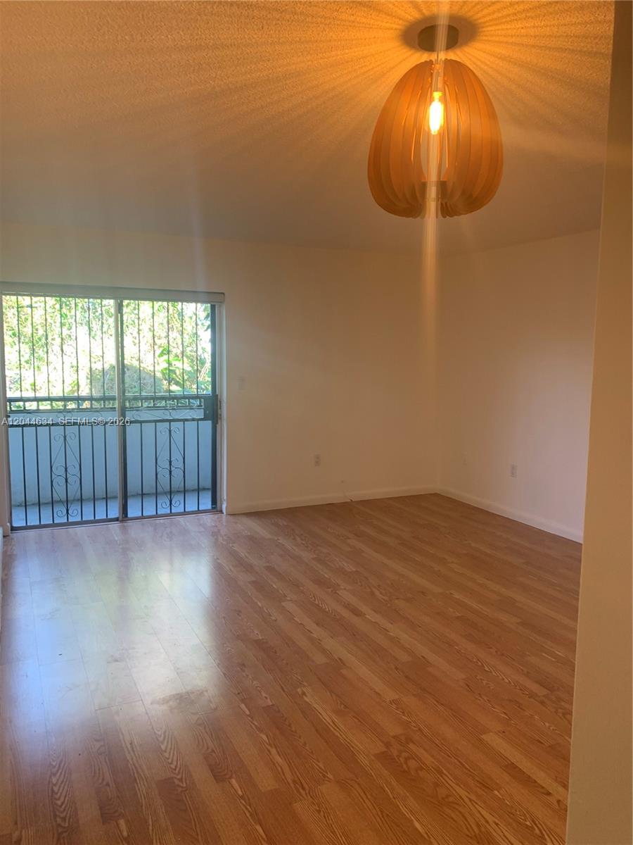 2460 Southwest 18th Avenue, Unit 1205 Miami, FL 33133 - Photo 4 of 21 an empty room with wooden floor and windows