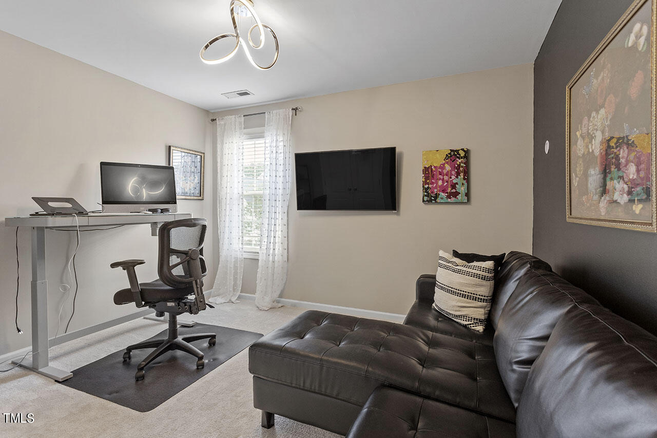 1329 Still Monument Way Raleigh, NC 27603 - Photo 30 of 42 a living room with furniture and a flat screen tv
