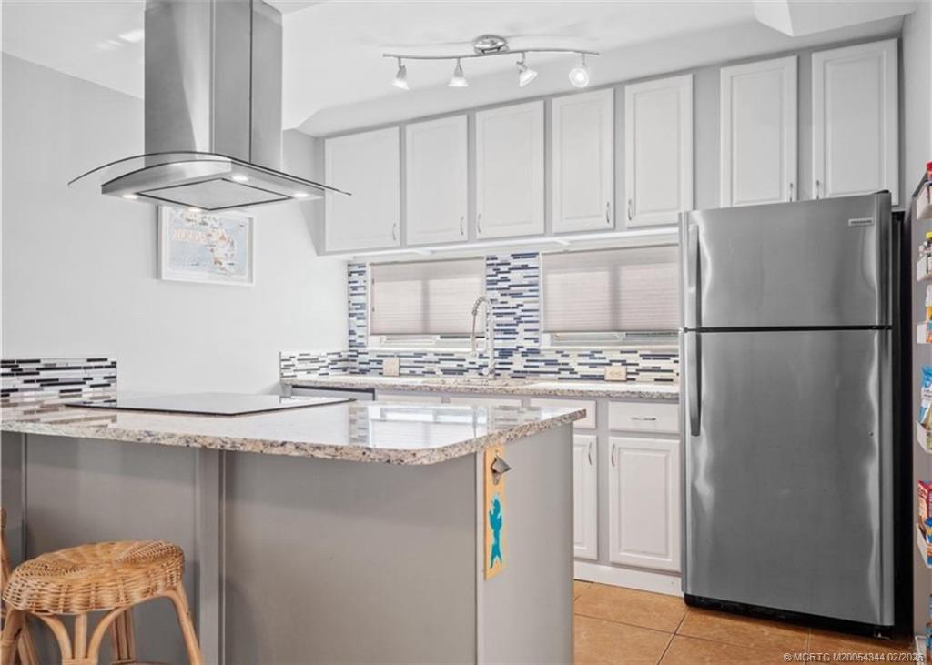 950 South Kanner Highway, Unit TH138 Stuart, FL 34994 - Photo 2 of 7 a kitchen with stainless steel appliances granite countertop a sink a refrigerator a stove and white cabinets