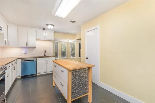 a kitchen with granite countertop white cabinets and white appliances