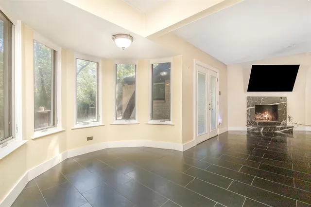a view of an empty room with furniture and a window