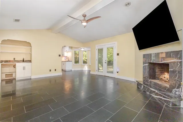 a view of an empty room with a fireplace and a flat screen tv