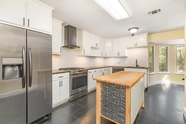a kitchen with stainless steel appliances granite countertop a sink stove and refrigerator