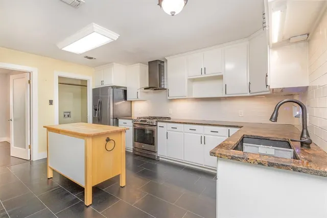 a kitchen with stainless steel appliances granite countertop a sink stove and refrigerator