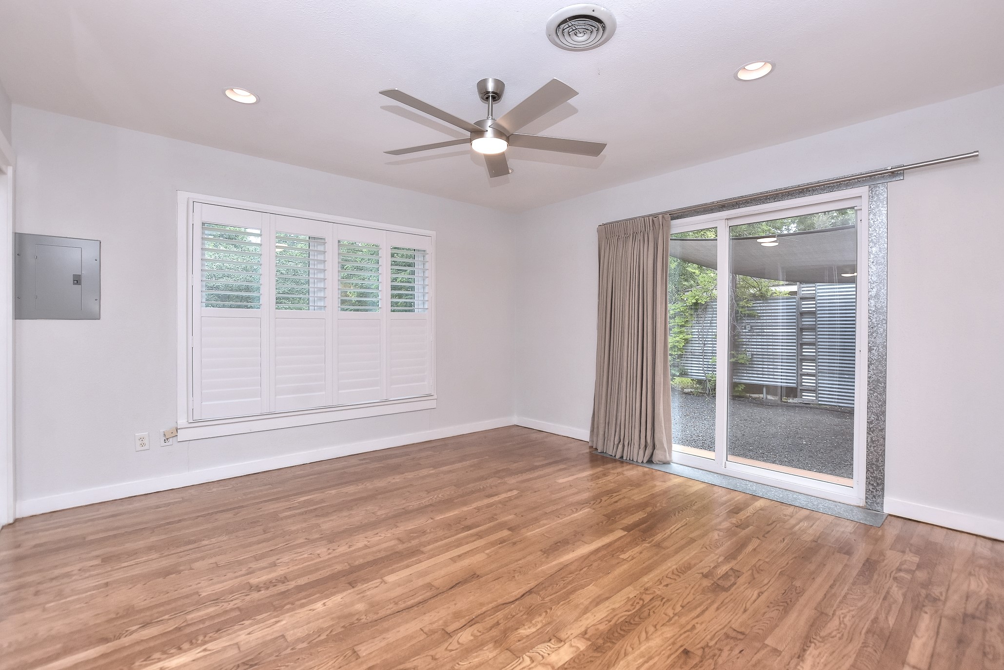 1309 Ridgemont Drive Austin, TX 78723 - Photo 18 of 35 Nice primary suite with recessed lighting, vintage hardwood floors, plantation shutters and energy efficient sliding back doors that open to a private back yard entertaining space!