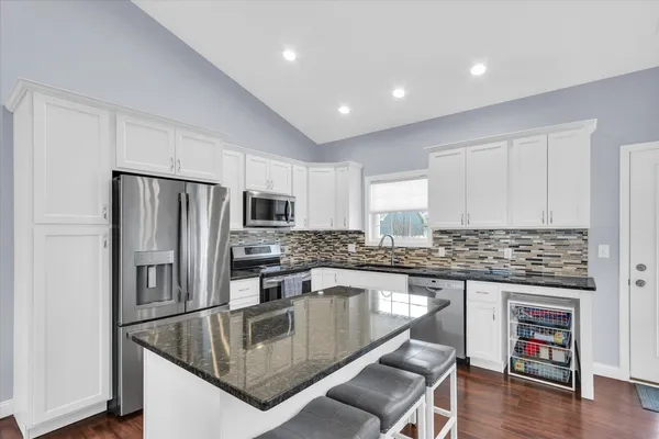 a kitchen with kitchen island a counter top space stainless steel appliances and cabinets