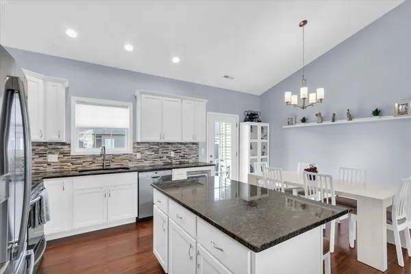 a kitchen with granite countertop a sink a center island and cabinets