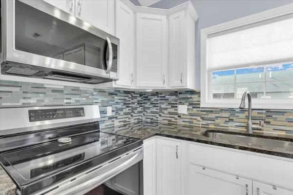 a kitchen with sink stainless steel appliances and a window