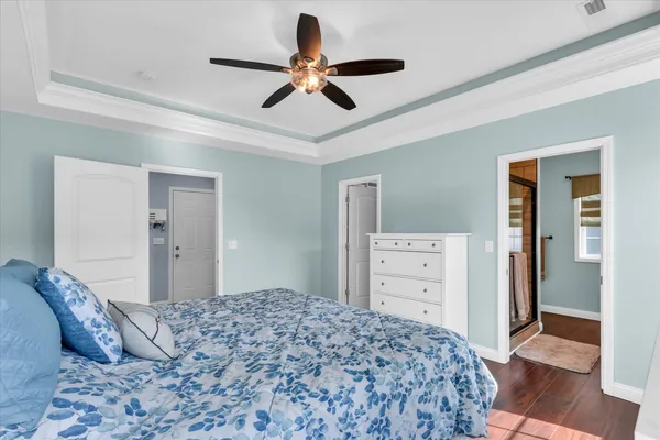 a bedroom with a bed and wooden floor