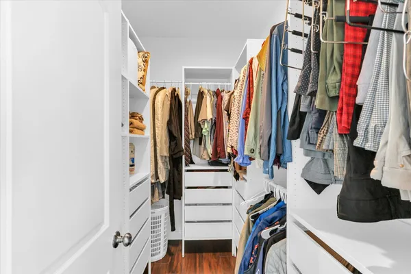 a view of walk in closet with clothes and shoes