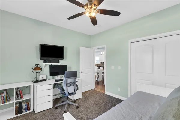 a view of a workspace with furniture and a ceiling fan