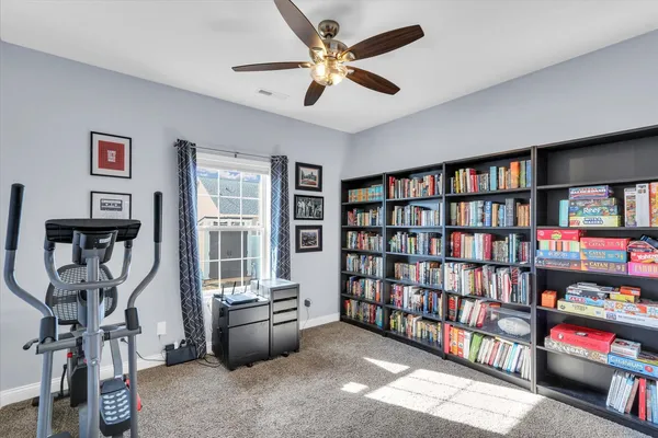 a living room with lots of books and a window