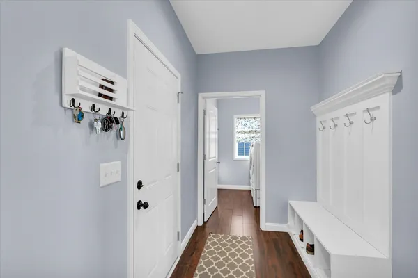 a view of a hallway with bathroom and wooden floor